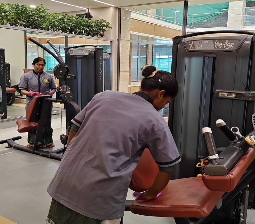 Housekeeping staff sanitizing gym equipment at Gold's Gym Ranchi