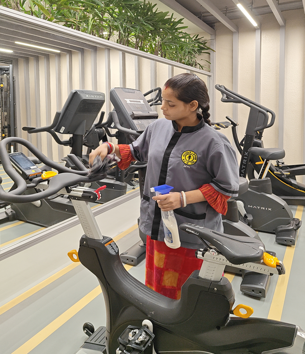 Housekeeping staff cleaning the gym floor at Gold's Gym Ranchi